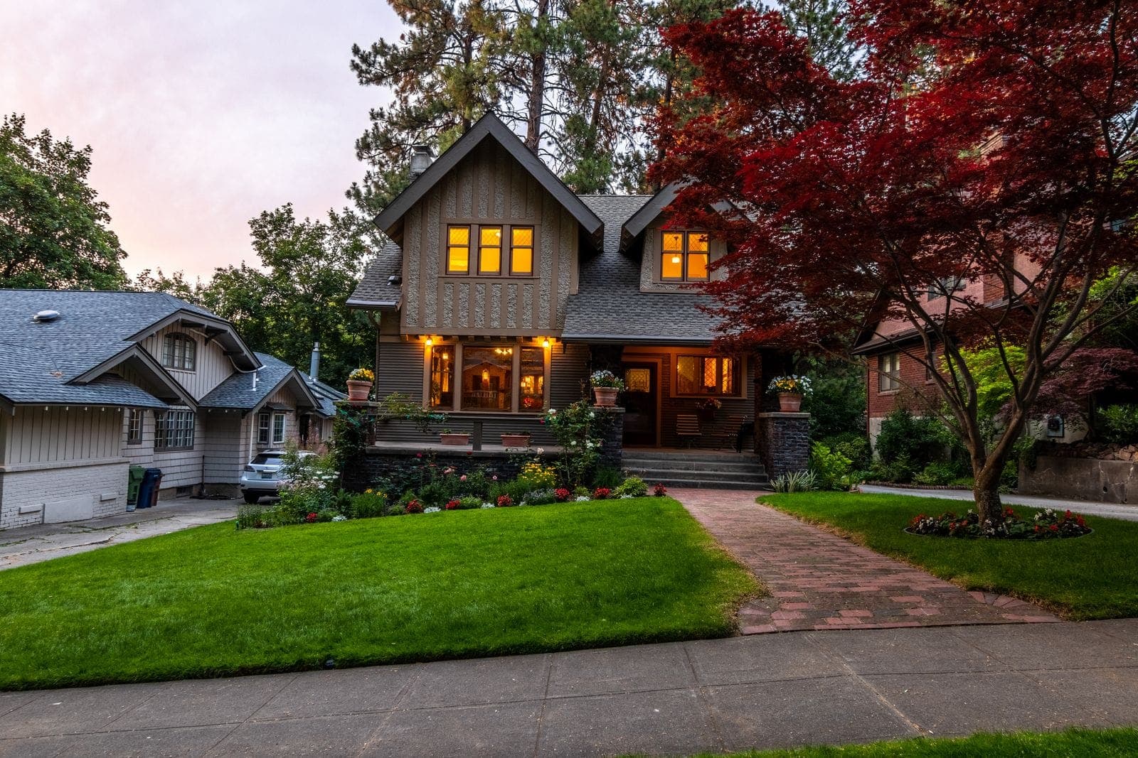 A warm craftsman home with glowing windows at dusk