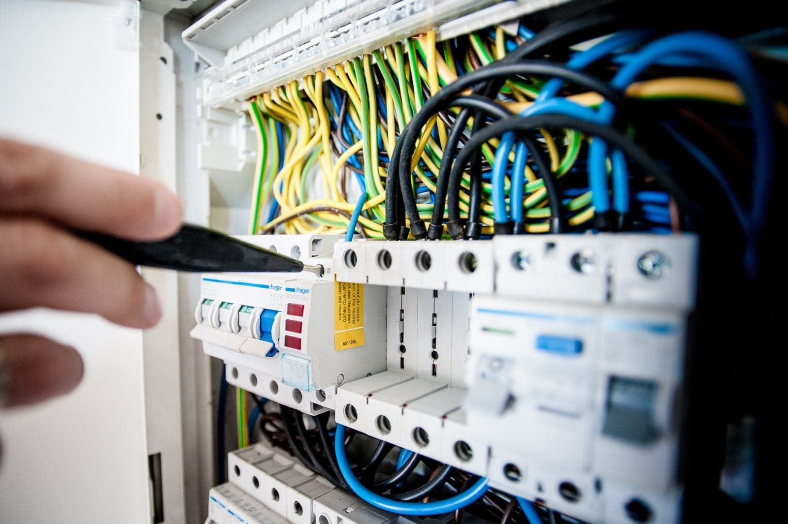 An electrician working on a breaker panel