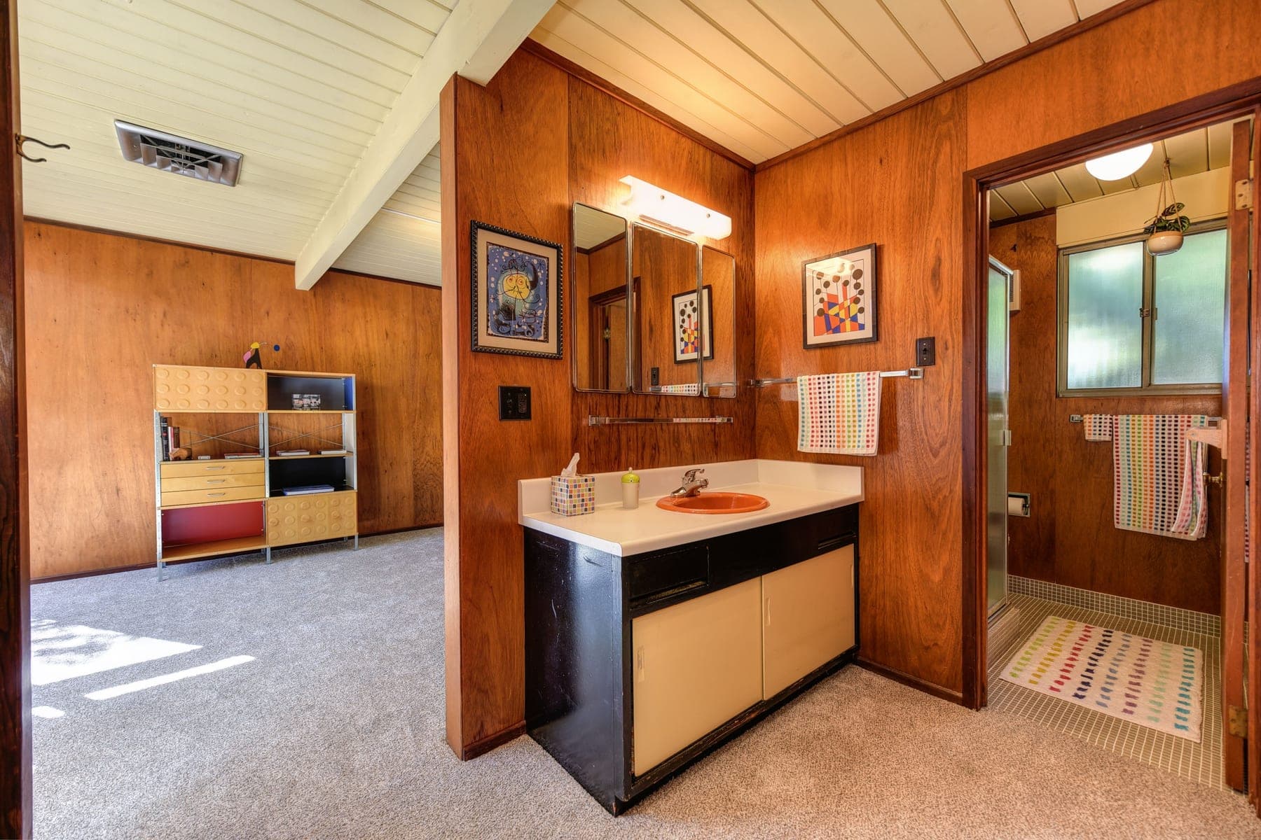 Vintage mid-century bathroom with wood paneling, an orange sink and original fixtures