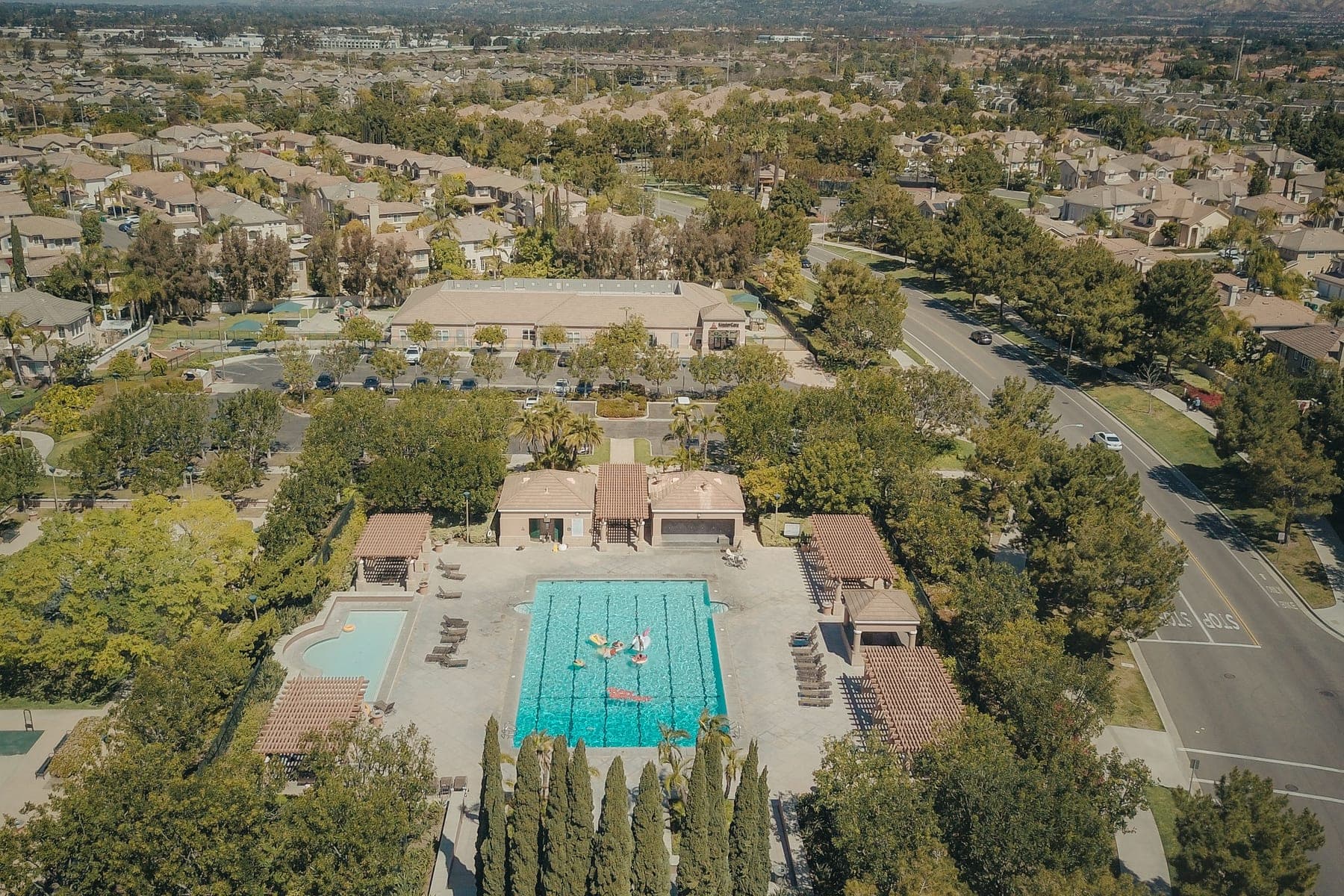 Aerial view of a planned neighborhood with a shared community pool and tile roofs